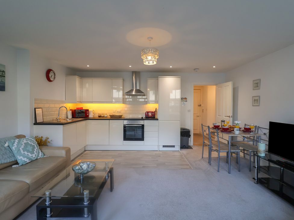A living room with a kitchen area and dining table at Stylish Central Ipswich Apartment Near the Waterfront with Parking in Ipswich