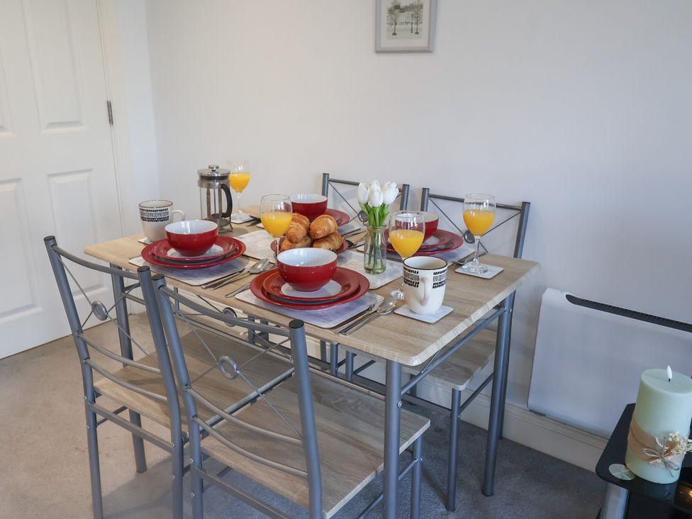A dining table set for breakfast with plates and drinks at Stylish Central Ipswich Apartment Near the Waterfront with Parking in Ipswich