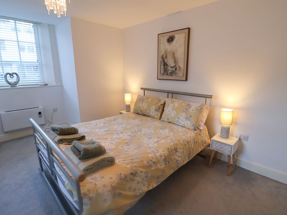 A bedroom with a bed, lamps, and a picture at Stylish Central Ipswich Apartment Near the Waterfront with Parking, Ipswich