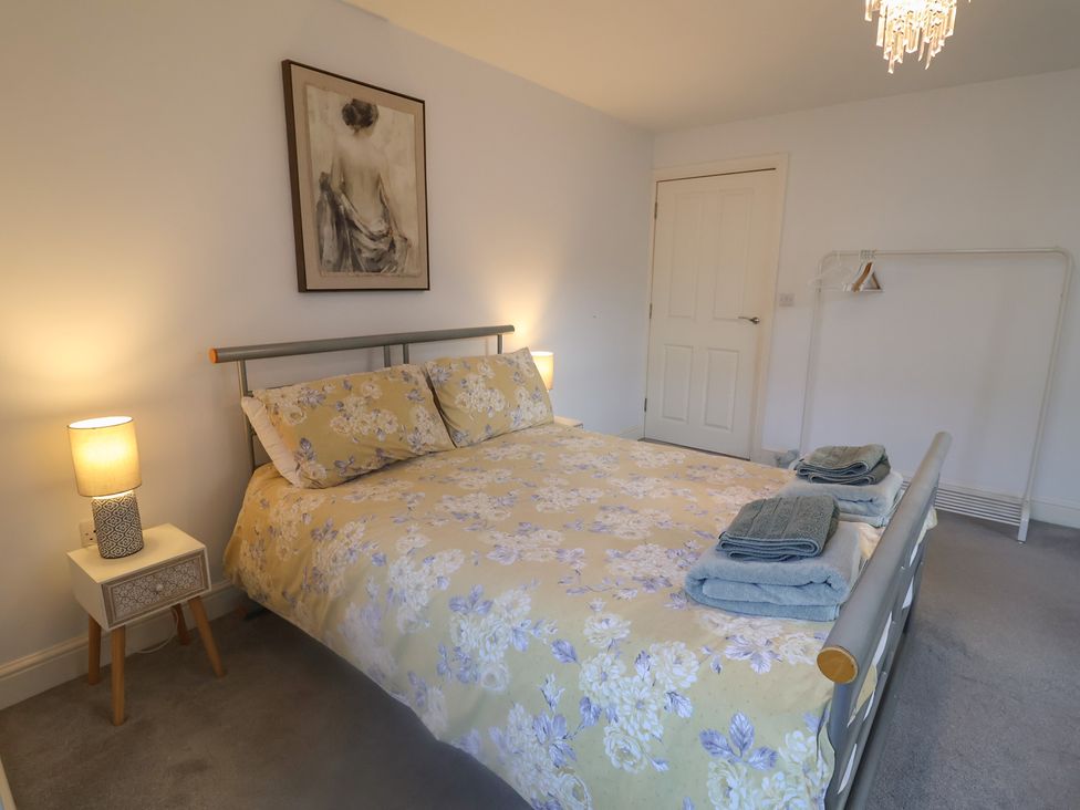 A bedroom with a bed, bedside table, and artwork at Stylish Central Ipswich Apartment Near the Waterfront with Parking, Ipswich