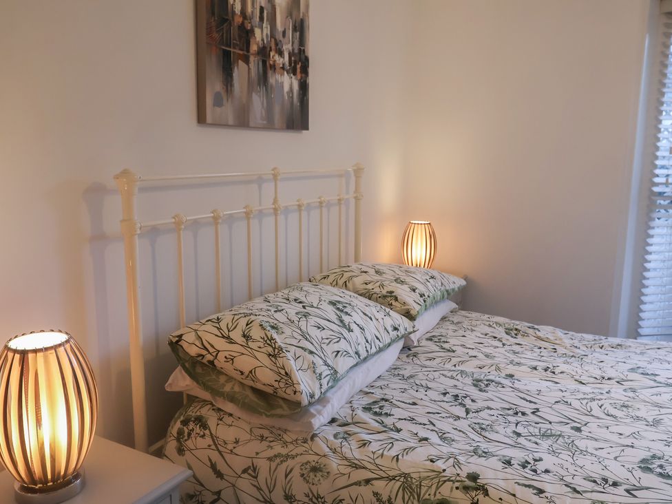 A bedroom with a bed and lamps at Stylish Central Ipswich Apartment Near the Waterfront with Parking Ipswich