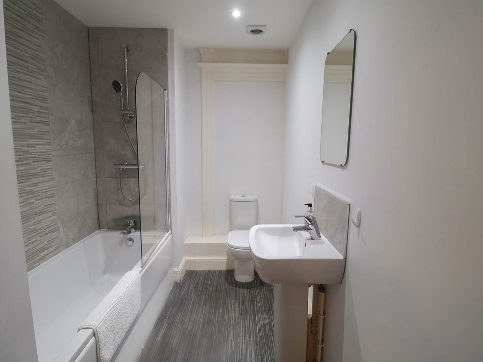A bathroom with a bathtub, shower, sink, and toilet at Stylish Central Ipswich Apartment Near the Waterfront with Parking in Ipswich