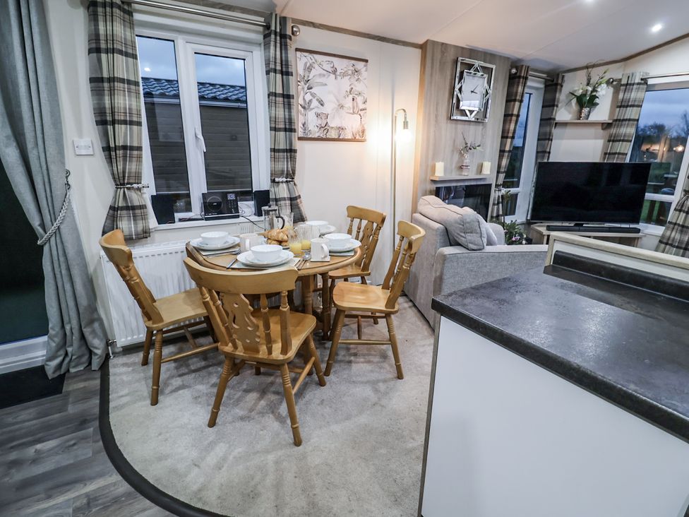 A dining area with a table and chairs at Lakeside Lodge in Stonham Aspal