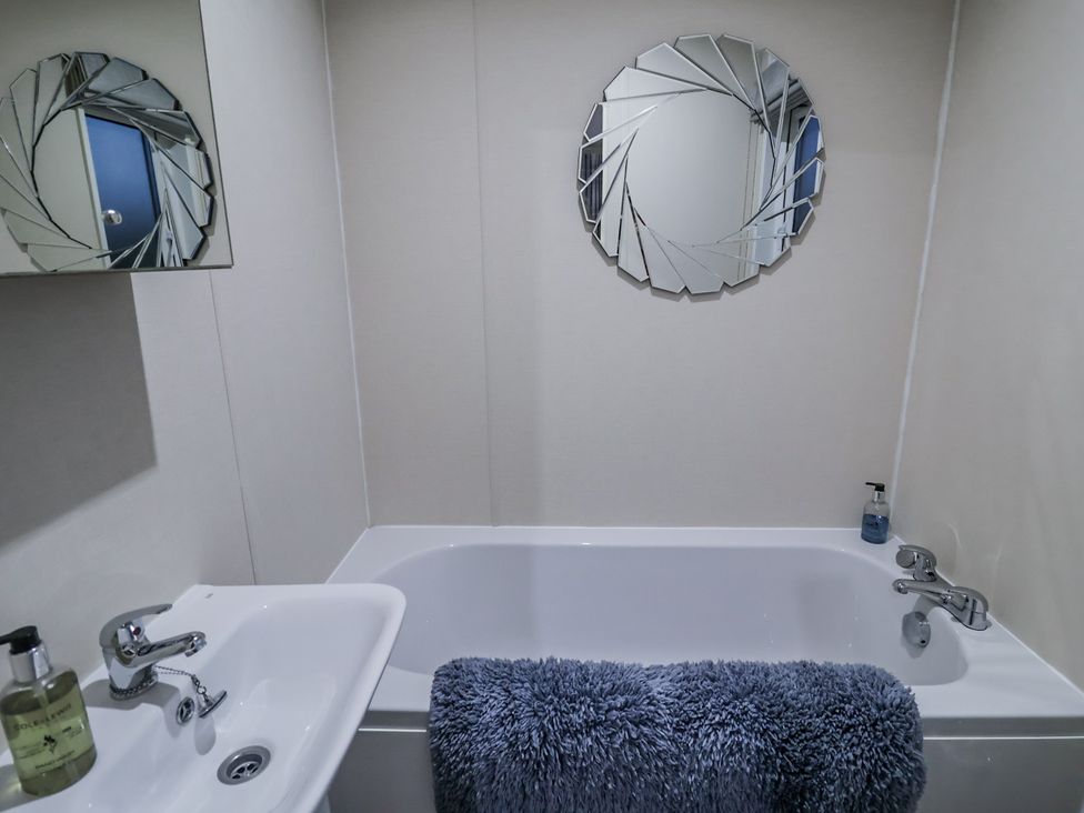 A bathroom with a bathtub and sink at Lakeside Lodge in Stonham Aspal