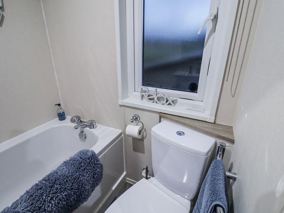 A bathroom with a bathtub, toilet, and sink at Lakeside Lodge in Stonham Aspal