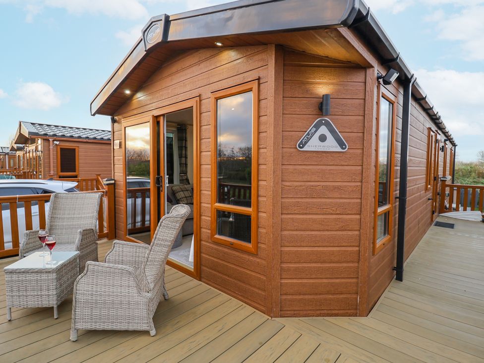 An outdoor seating area with chairs and a table at Lakeside Lodge in Stonham Aspal