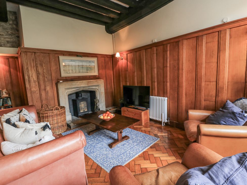 A living room with a fireplace and sofa at Ostlers in Burford