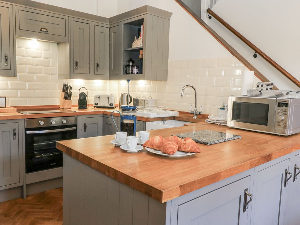 A kitchen with cabinets, a sink, and kitchen appliances at Ostlers Burford