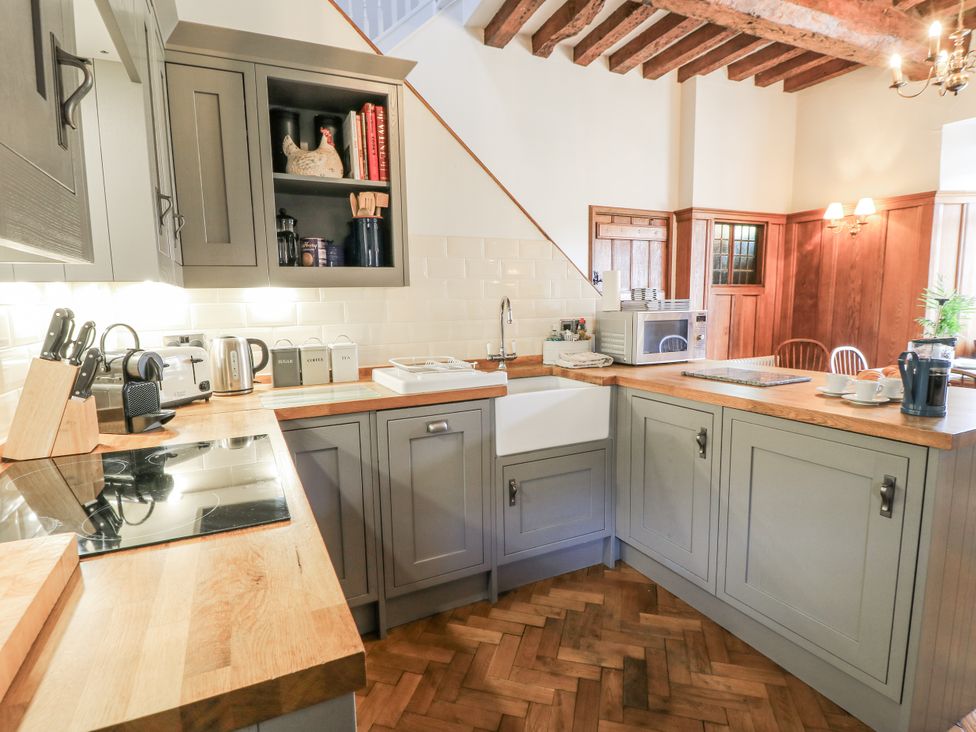 A kitchen with cabinets and appliances at Ostlers in Burford