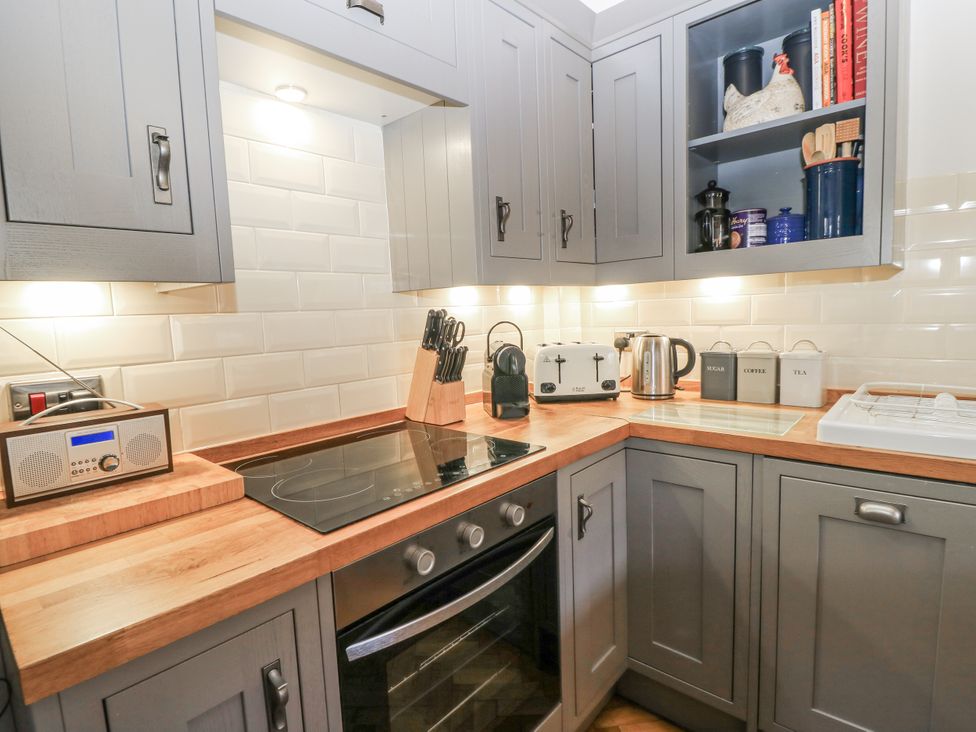 A kitchen with cabinets and appliances at Ostlers in Burford