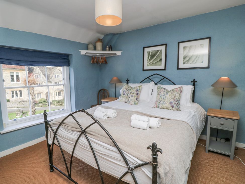 A bedroom with a bed and nightstand at Ostlers in Burford