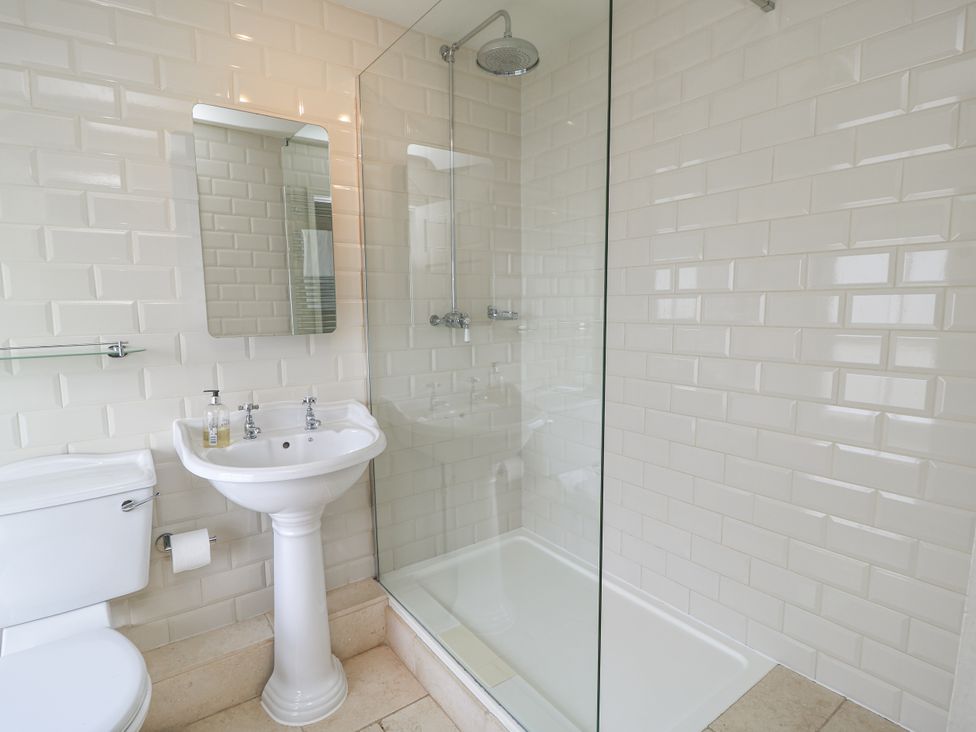 A bathroom with a shower, sink, and toilet at Ostlers, Burford