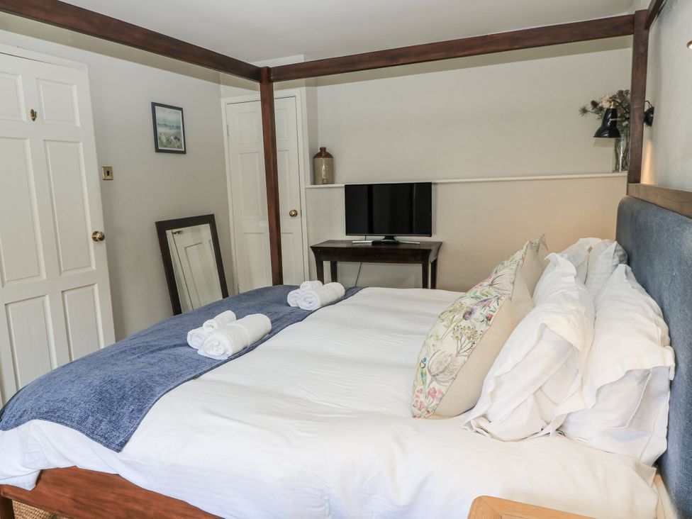 A bedroom with a bed and television at Ostlers Burford