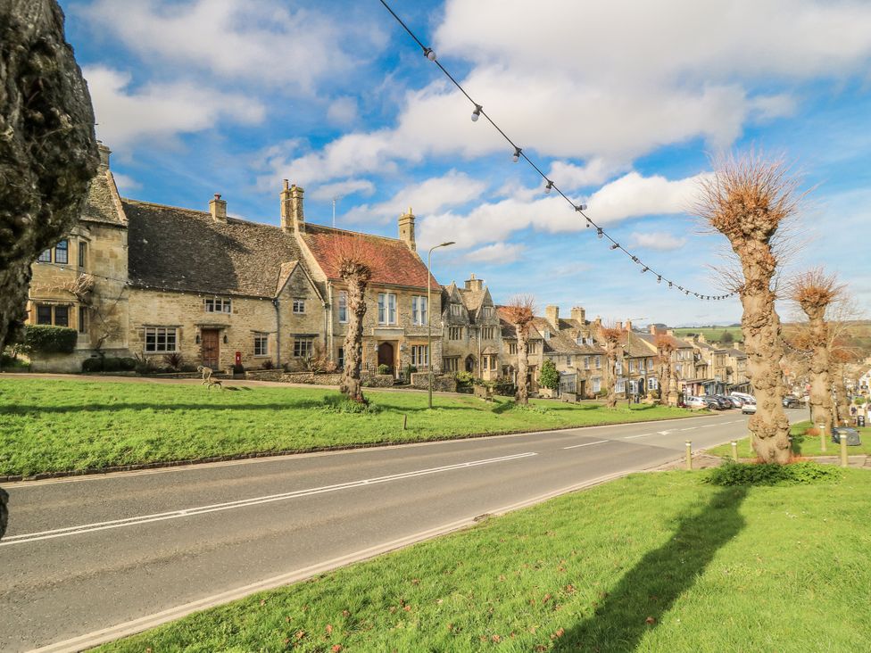 Houses along a road with trees and grass at Ostlers in Burford