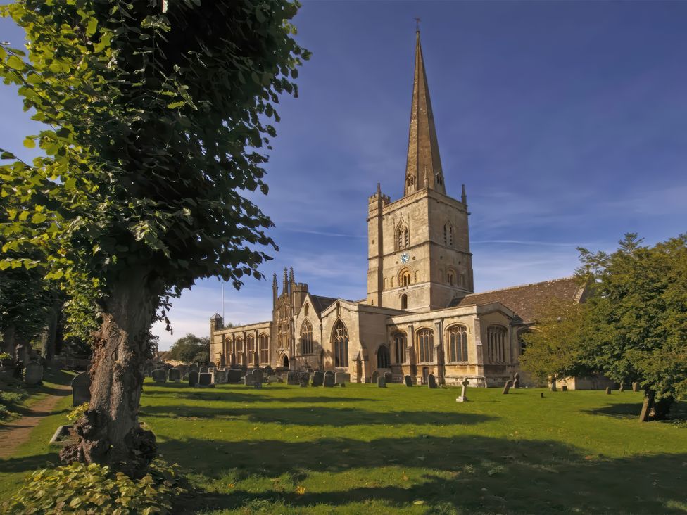 A church with a tall tower and graveyard at Ostlers Burford