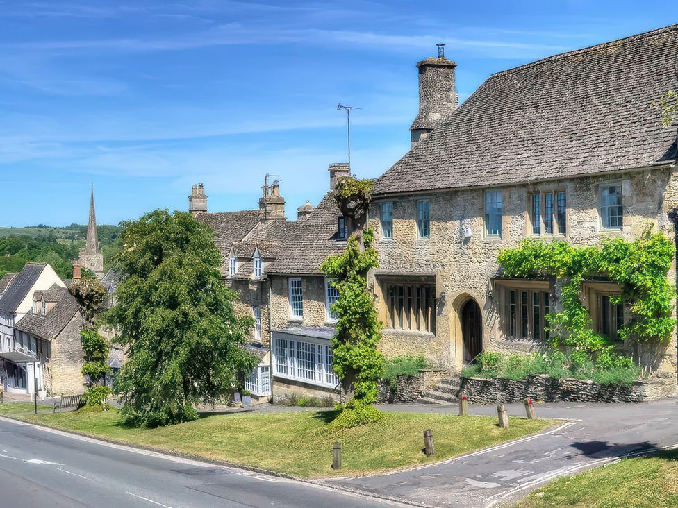 A building with a tree and road at Ostlers in Burford
