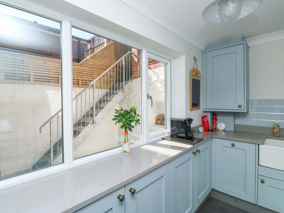 A kitchen with a window and staircase view at 43 Sandquay Road Dartmouth