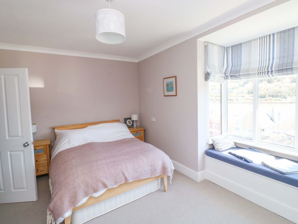 A bedroom with a bed and window seat at 43 Sandquay Road Dartmouth