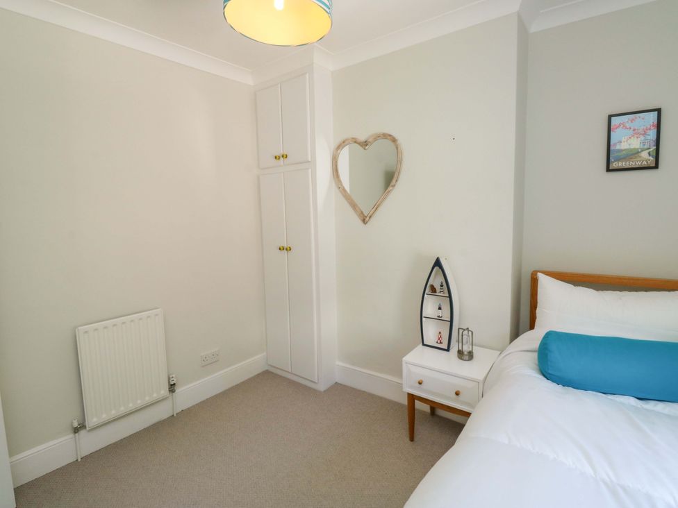 A bedroom with a bed and cabinet at 43 Sandquay Road, Dartmouth