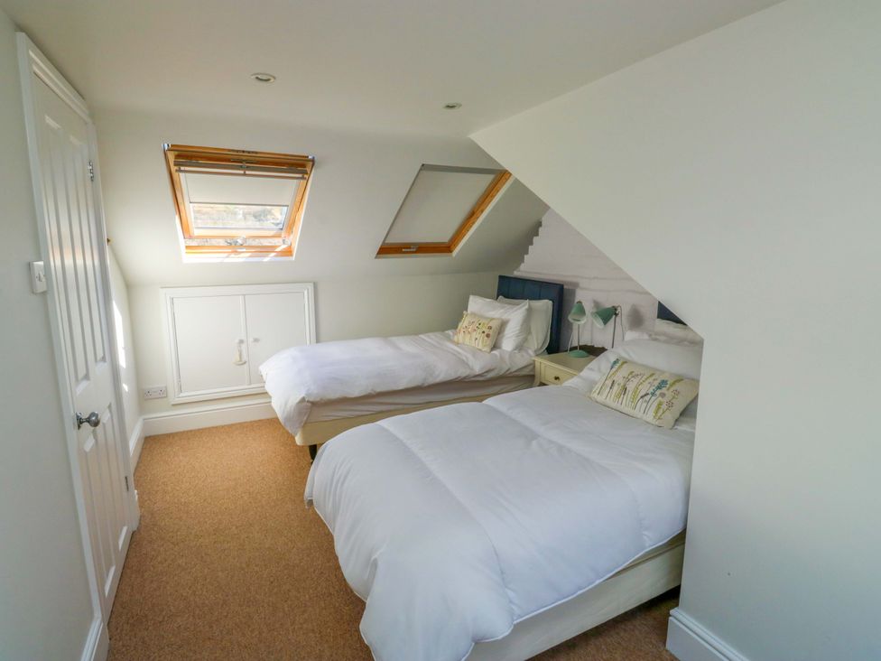 A bedroom with two beds and a wardrobe at 43 Sandquay Road in Dartmouth