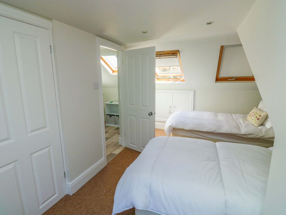 A bedroom with two beds and a door at 43 Sandquay Road in Dartmouth