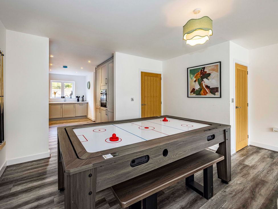 A games room with an air hockey table and view of kitchen at 3 Riverside Mews Derby
