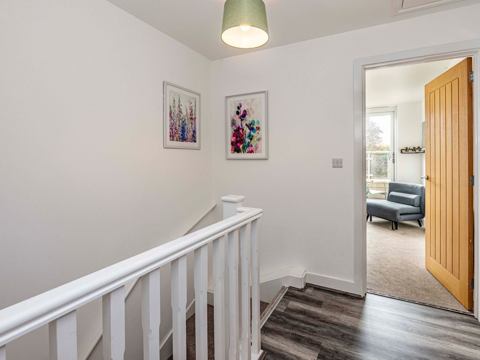 A hallway with a staircase and door leading to a room at 3 Riverside Mews in Derby