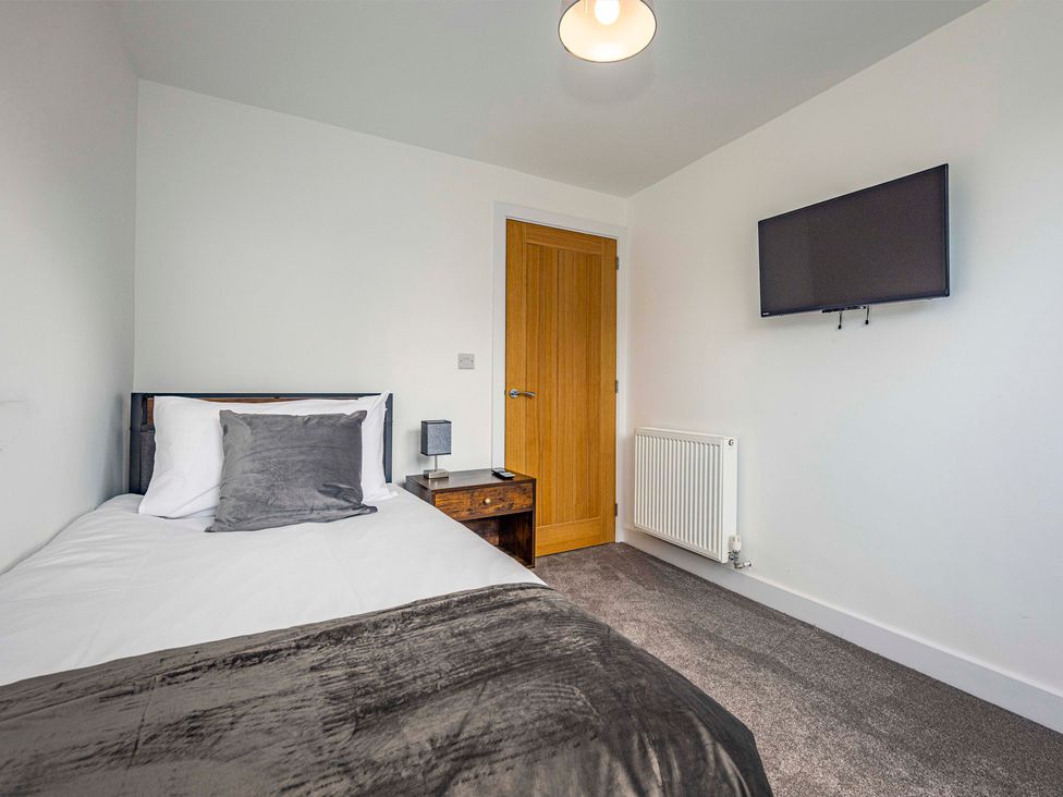A bedroom with a bed and television at 3 Riverside Mews in Derby