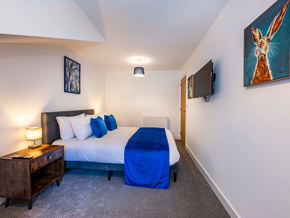 A bedroom with a bed and bedside table at 3 Riverside Mews in Derby