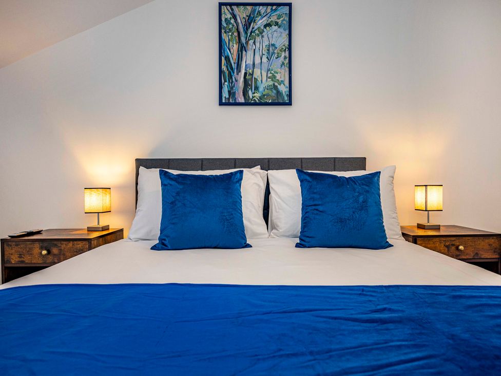 A bedroom with a bed and lamps at 3 Riverside Mews in Derby