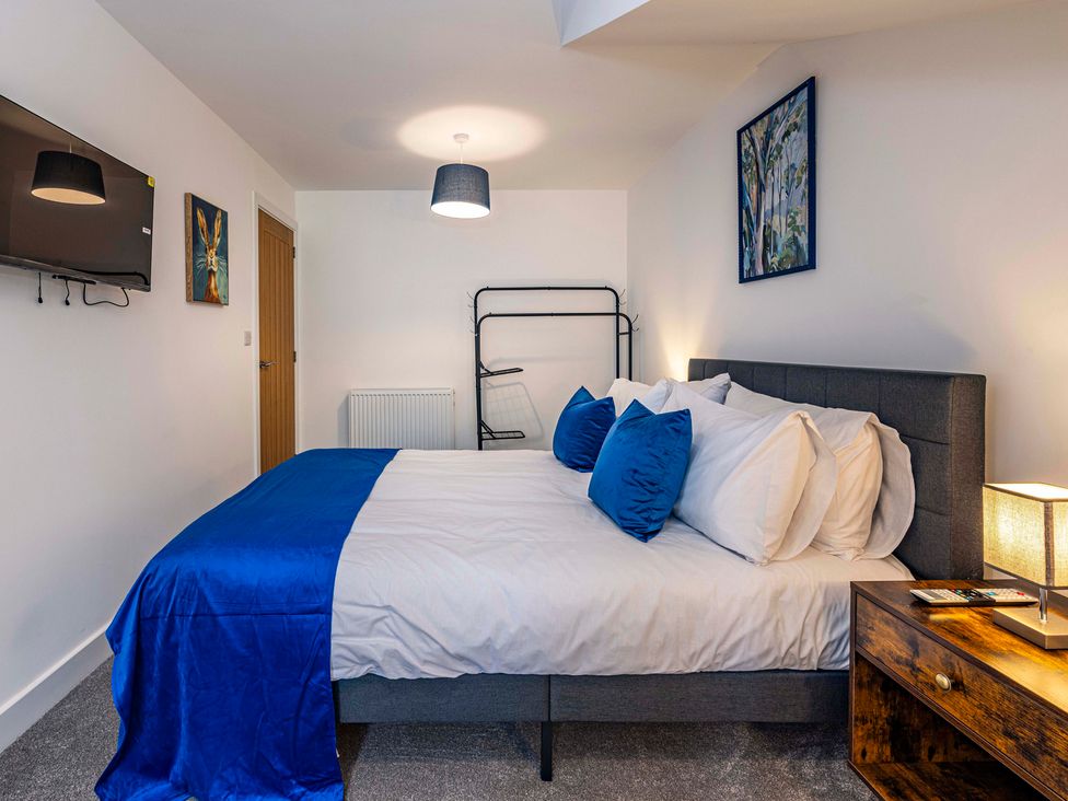 A bedroom with a bed and television at 3 Riverside Mews in Derby