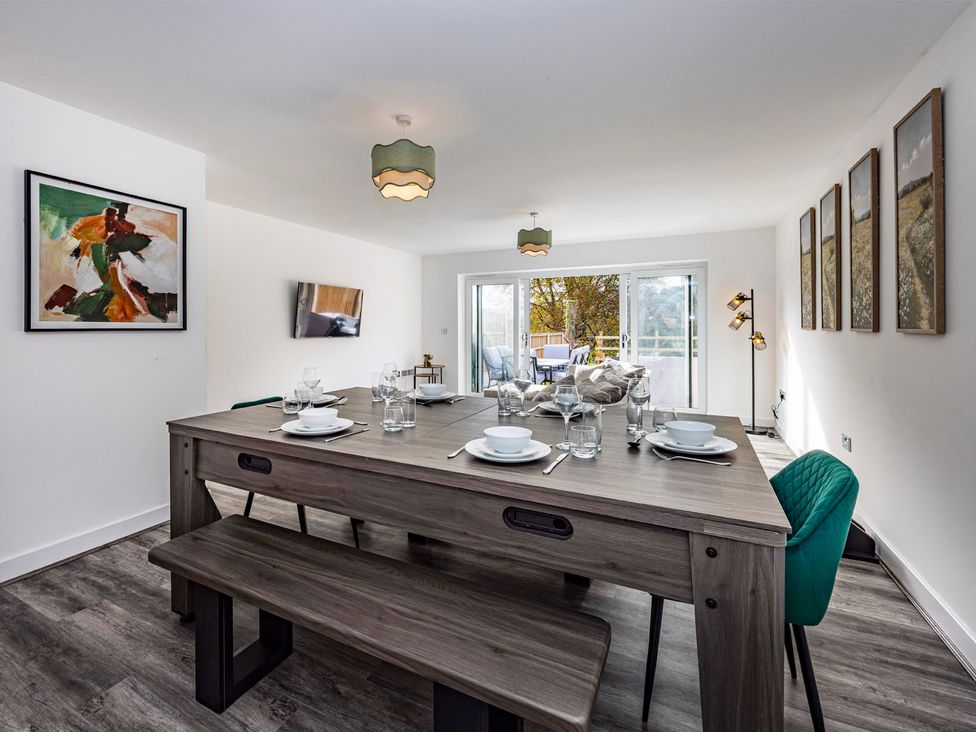 A dining room with a table set for meals at 4 Riverside Mews in Derby