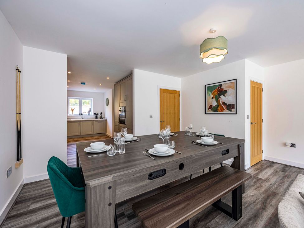 A dining room with a table set for meals at 4 Riverside Mews in Derby