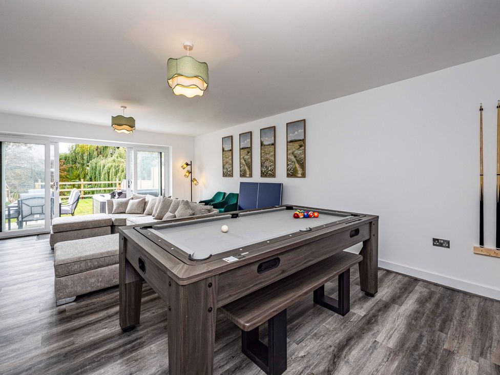 A living room with a pool table and sofa at 4 Riverside Mews in Derby