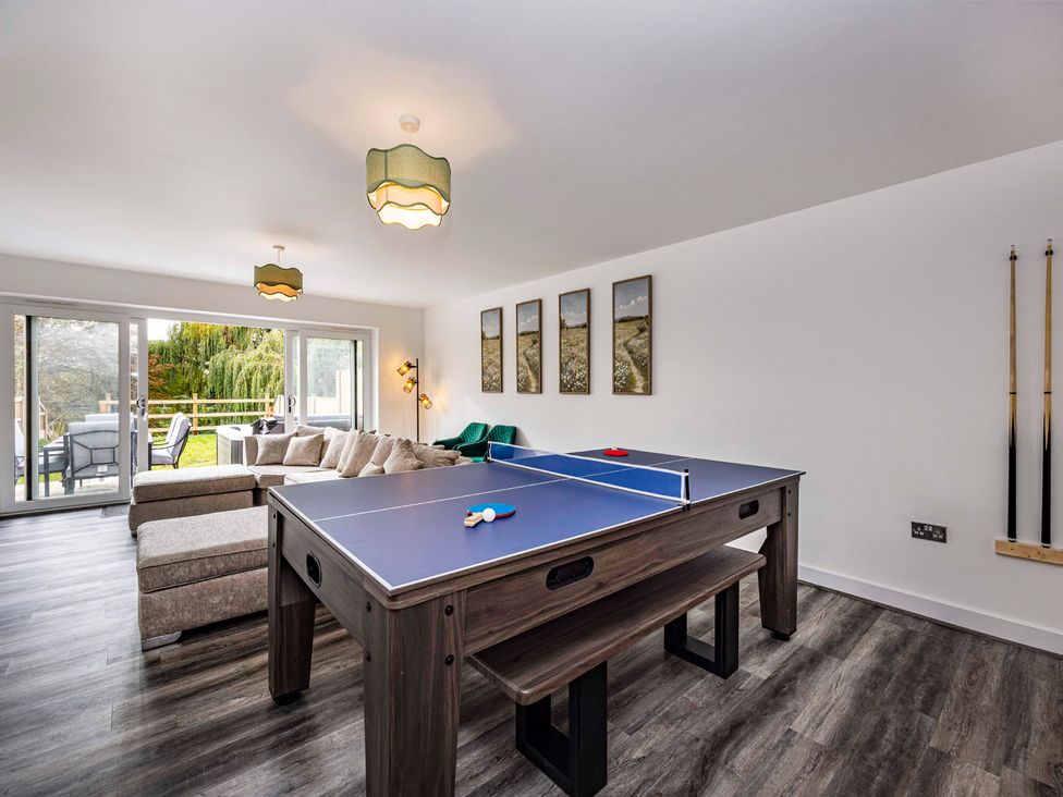 A living room with a ping pong table and sliding doors at 4 Riverside Mews in Derby