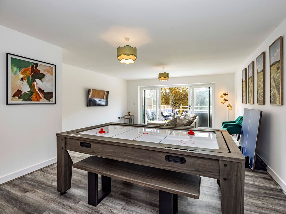 A living room with an air hockey table and a sofa at 6 Riverside Mews in Derby