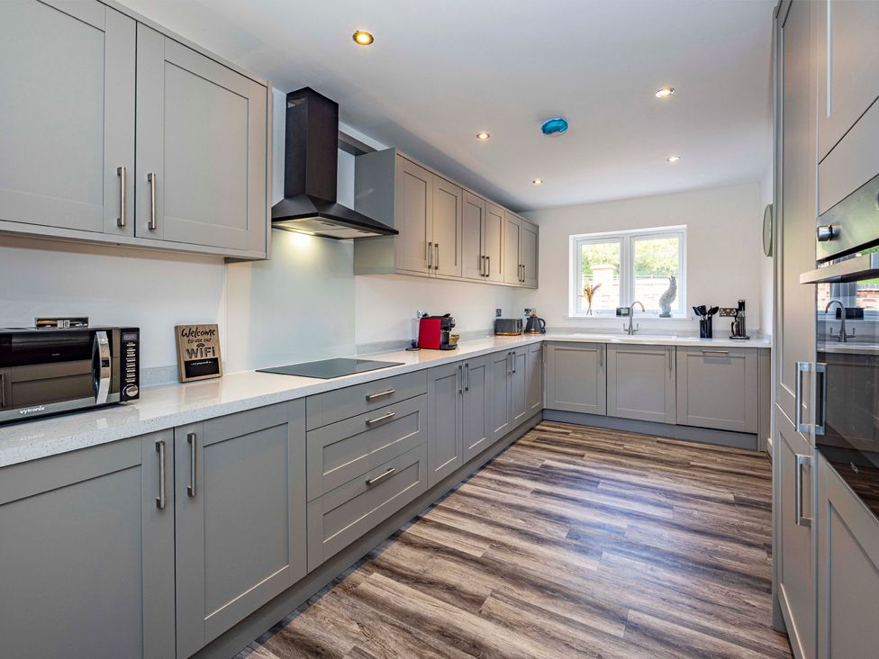 A kitchen with cabinets, microwave, and sink at 6 Riverside Mews in Derby