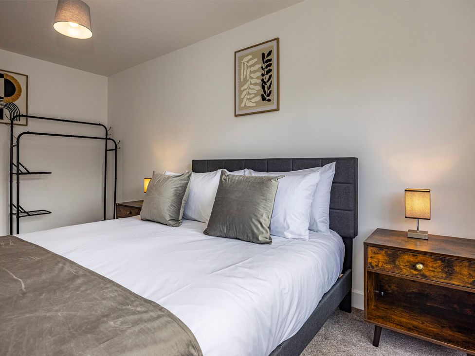 A bedroom with a bed and nightstand at 6 Riverside Mews in Derby