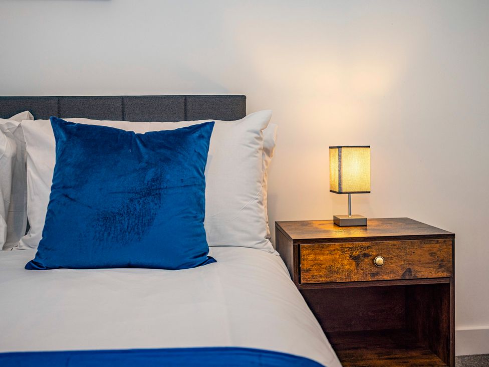 A bedroom with a bed and nightstand at 6 Riverside Mews Derby