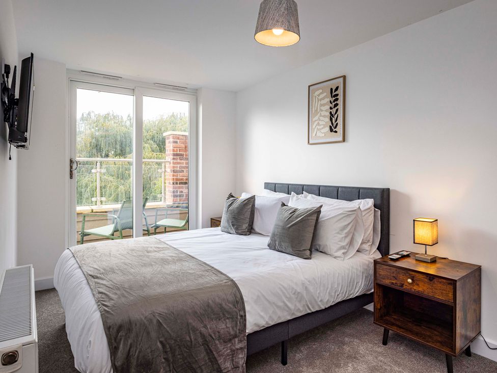 A bedroom with a bed and a television at 6 Riverside Mews in Derby