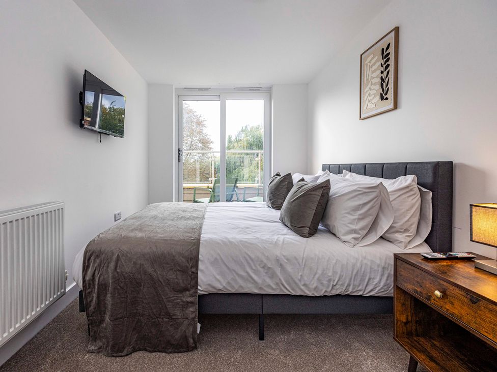 A bedroom with a bed and television at 6 Riverside Mews in Derby
