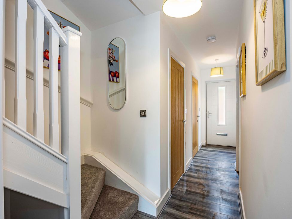 A hallway with a staircase and front door at 6 Riverside Mews in Derby