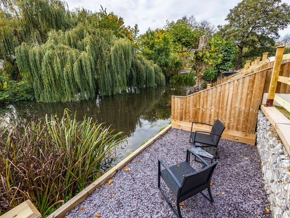 A garden with chairs near a pond at 6 Riverside Mews Derby