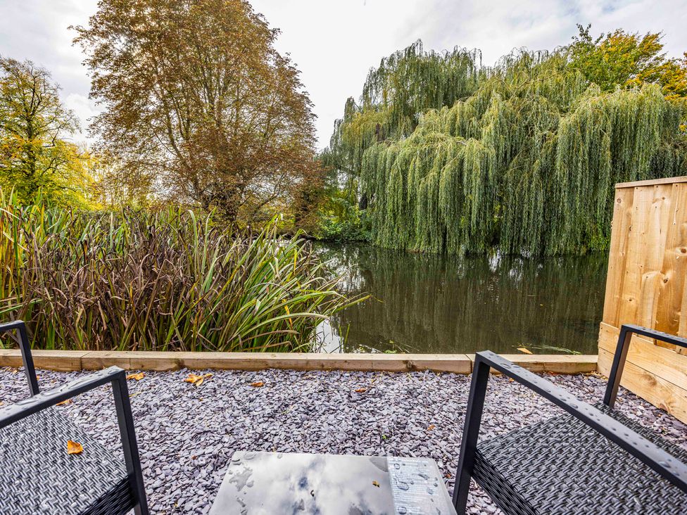 A garden area by the water with seating at 6 Riverside Mews Derby
