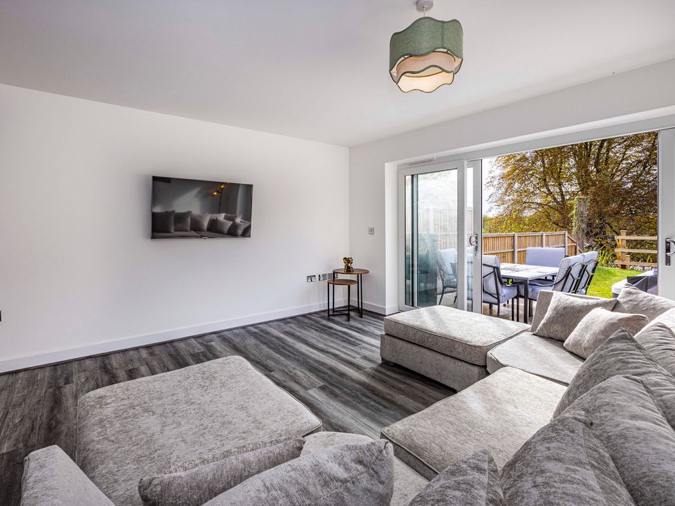 A living room with a sofa and a TV at 6 Riverside Mews in Derby