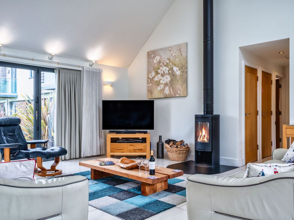 A living room with a television and coffee table at Beachcombers in Marhamchurch