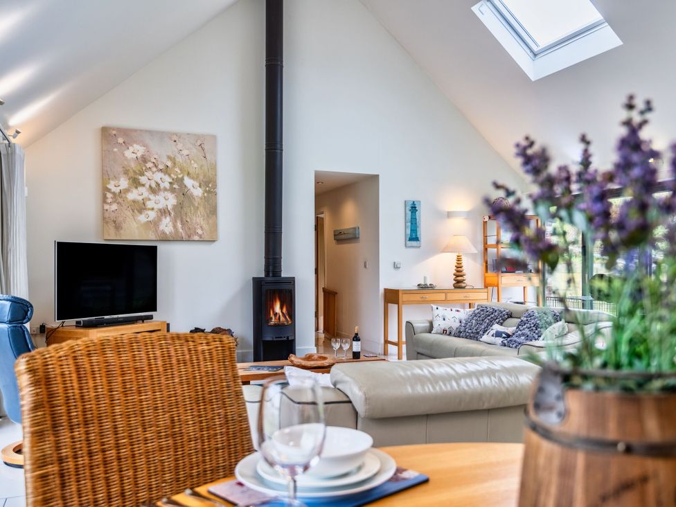 A living room with a television and a fireplace at Beachcombers in Marhamchurch