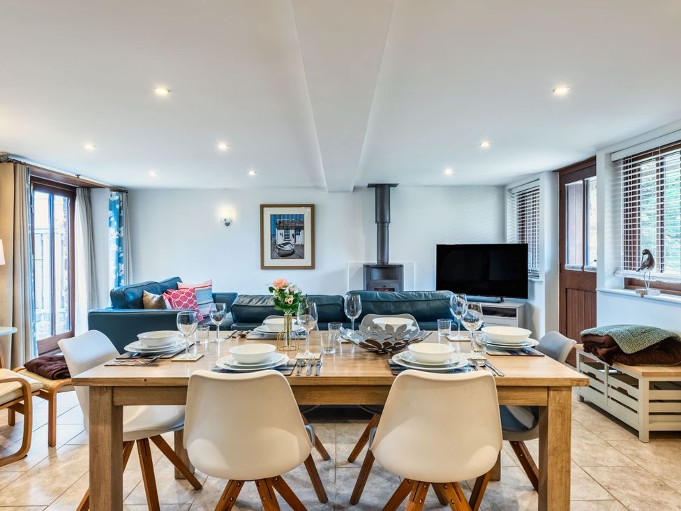 A dining room with a table set for dinner at Woodyplatt in Marhamchurch