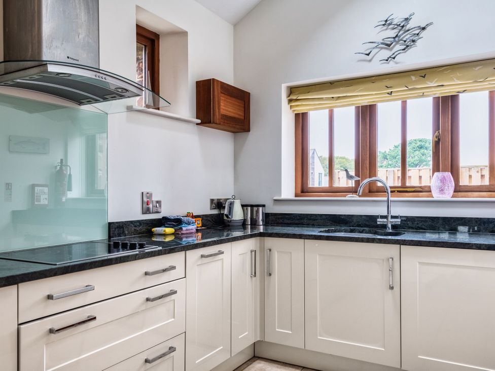 A kitchen with a sink and kettle at Woodyplatt in Marhamchurch