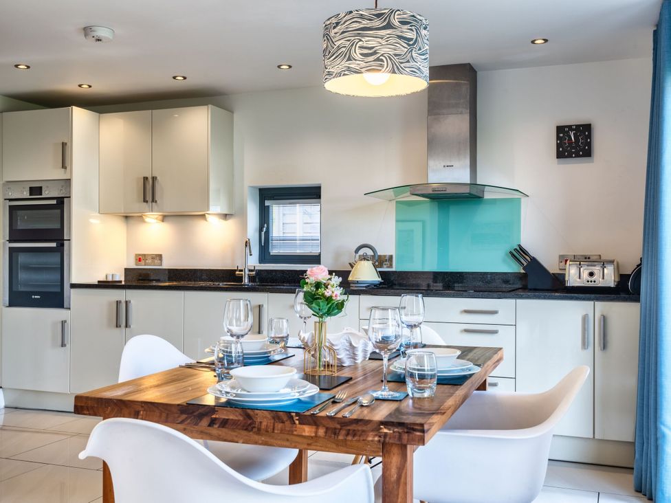 A kitchen with a dining table and chairs at Chapel Park in Marhamchurch